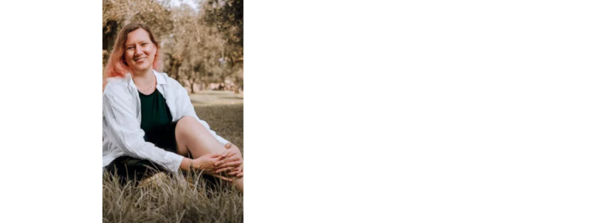 Svenja Tasler seated outdoors in dry grass, wearing a white jacket