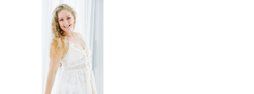 Carly Killen in a white dress, photographed against a bright window